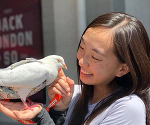 Girl smiling while holding a dove - Palomacy Pigeon & Dove Adoptions