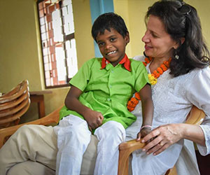 Smiling little boy on doctor's lap - Miracle Foundation