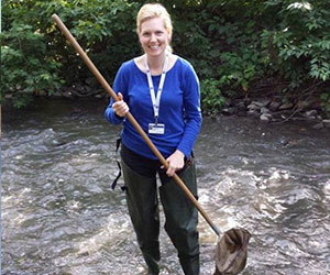 Volunteer cleaning up a stream - Earth Force