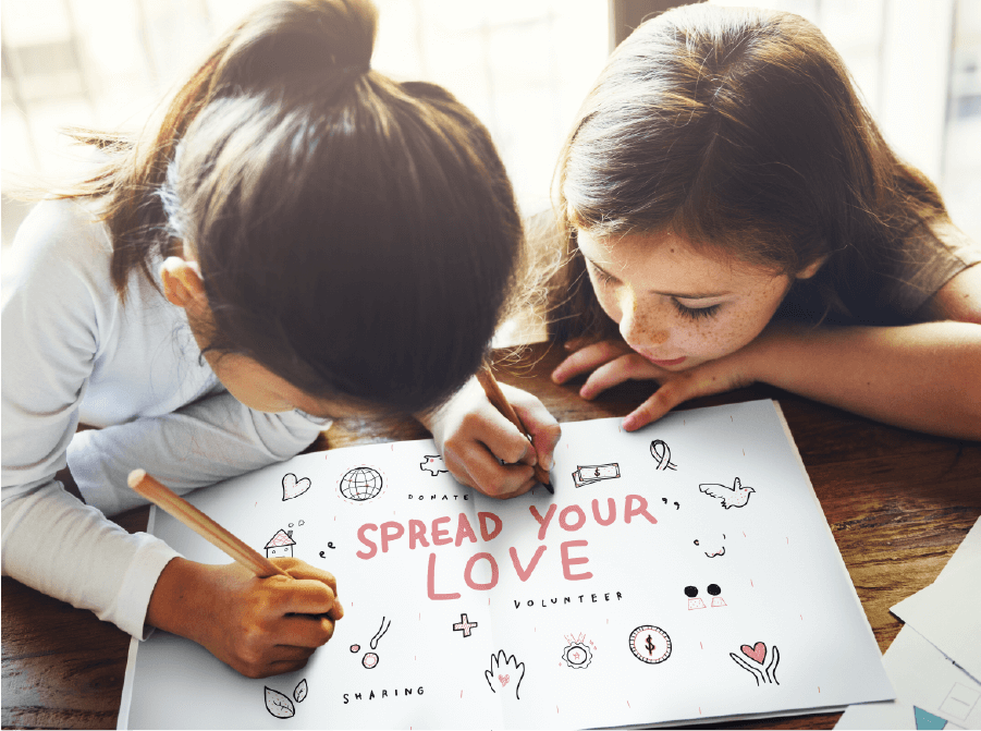 two cute girls drawing on a notebook that reads Spread Your Love