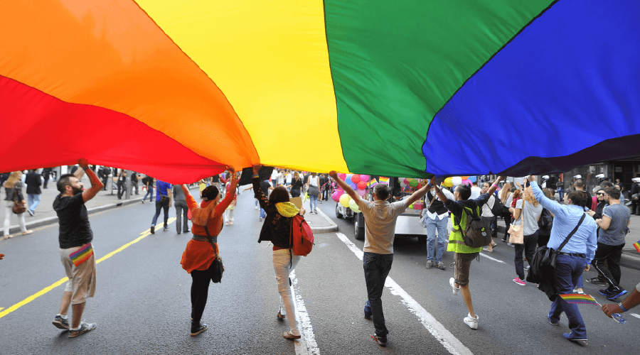 people holding pride flag over their heads