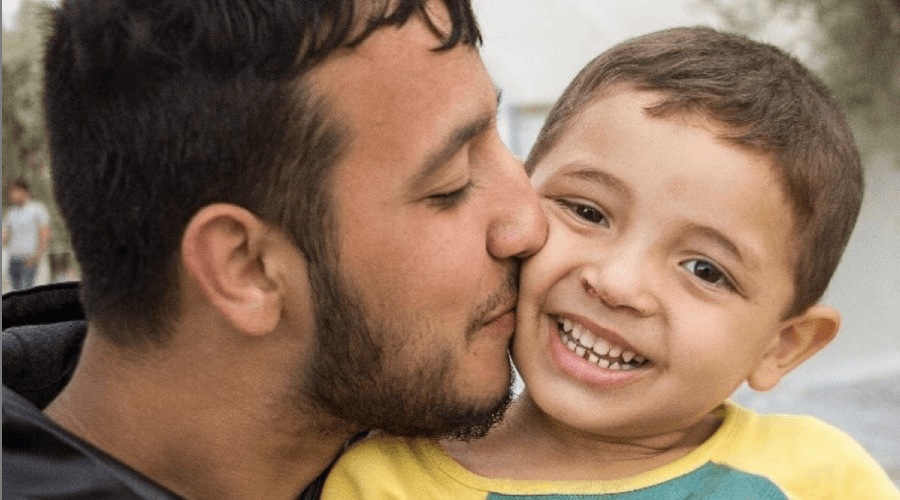 Dad kissing young son on the cheek