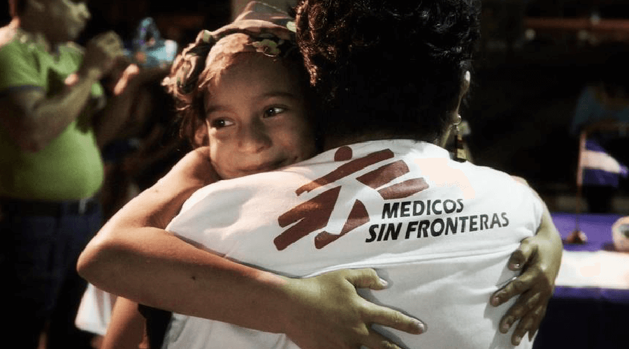 Girl hugging Doctor Without borders volunteer