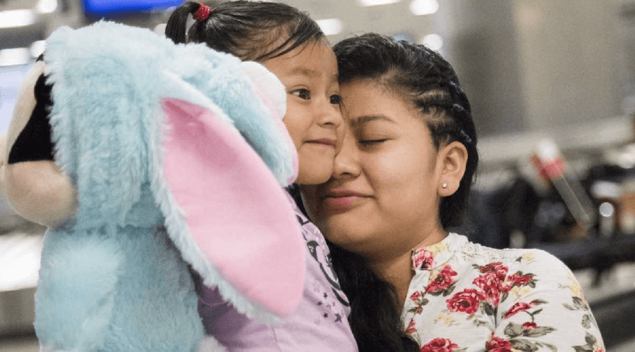 Woman hugging her daughter after months of being separated- RAICES