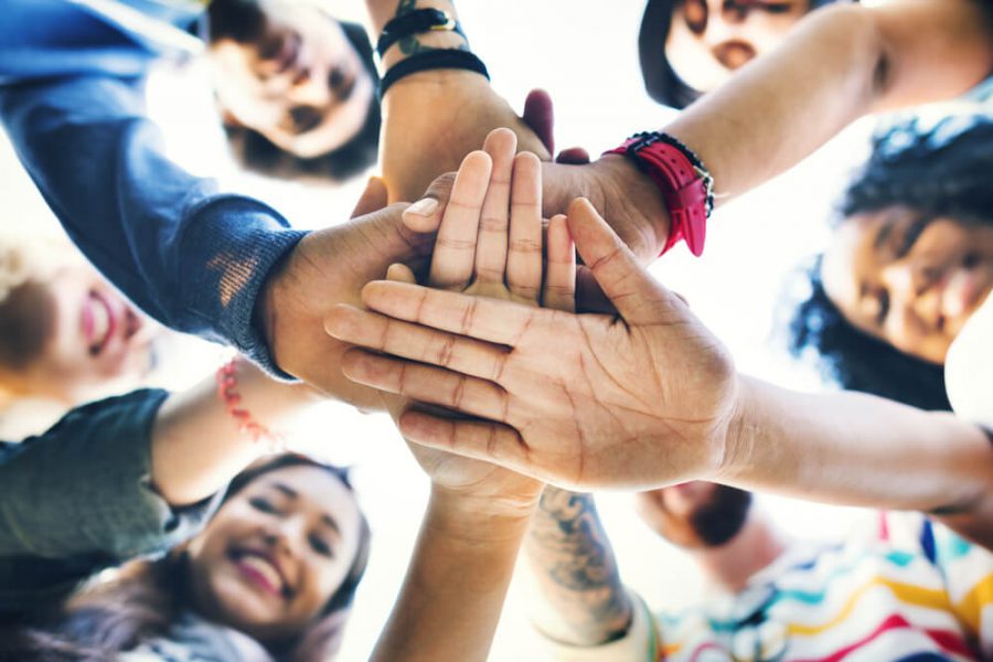 Diverse group of people stacking hands on each others