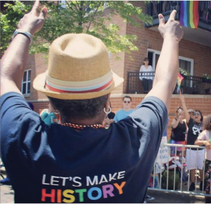 person wearing LGBTQ shirt that reads Let's make history