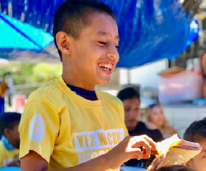 boy eating sandwich looking happy