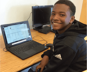 smiley teenage boy using a laptop