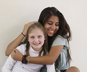 Volunteer hugging a little girl Arizona Lions Camp Tatiyee Inc