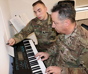 soldier teaching fellow soldier how to play the piano Starfish Foundation-Inc