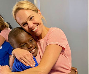 Little boy and a volunteer hugging New Life Furniture