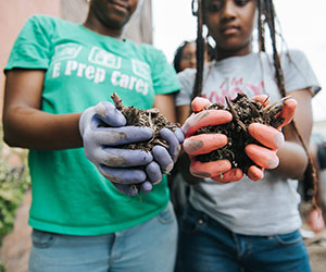 kid volunteers doing some planting Open Doors Academy