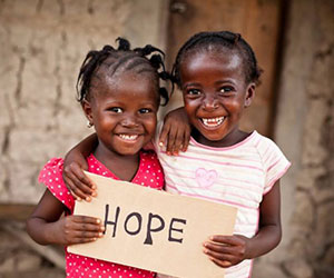 two kids holding up a hope sign A Childs Hope International, Inc.