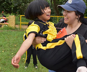 Volunteer carrying a little girl in Thailand Youthlinc