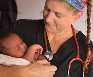 Volunteer holding a baby Midwives for Haiti Inc