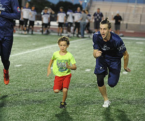 little kid running with his idol HopeKids