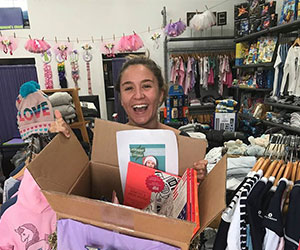 volunteer holding up a box of costumes for kids Speak Up For Kids Of Palm Beach County Inc