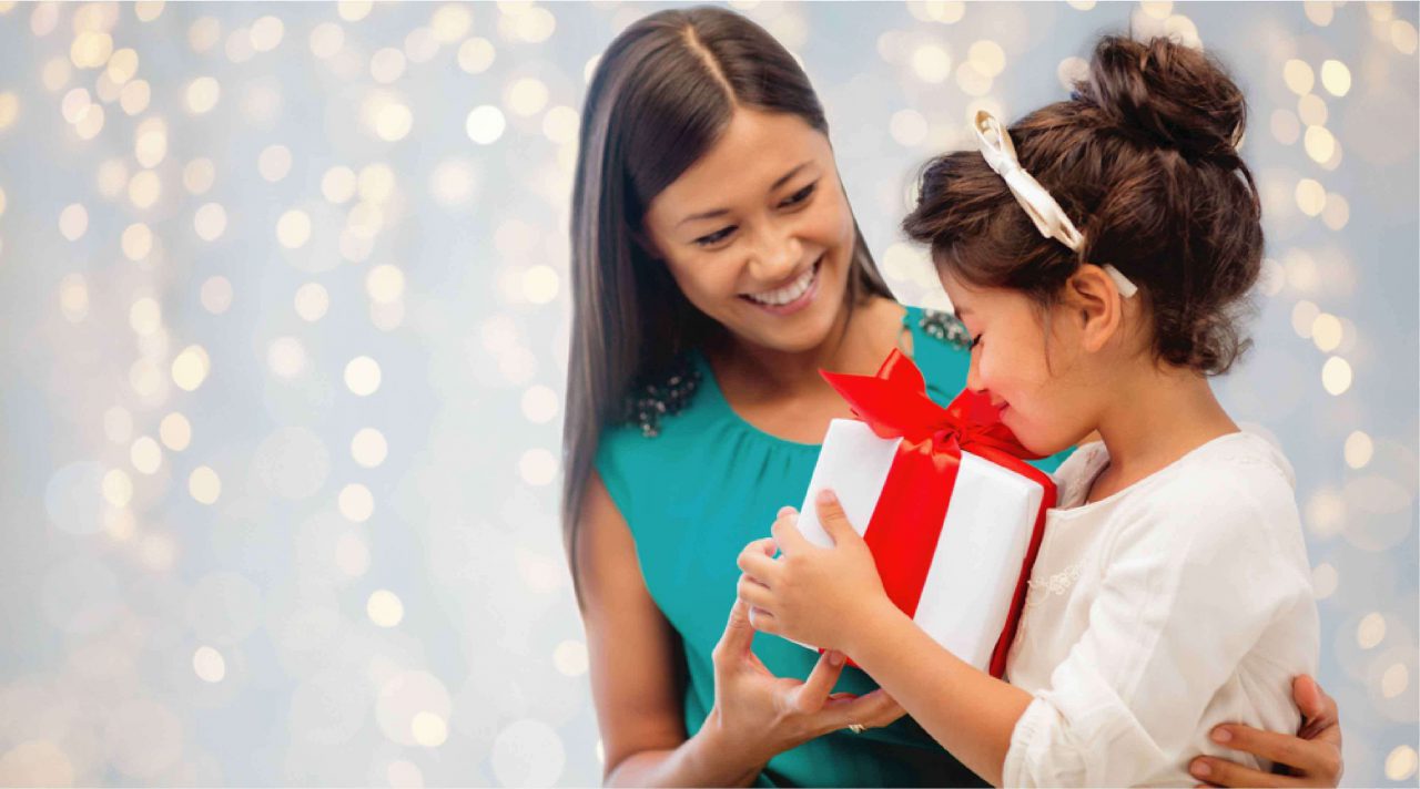 woman donating a gift to a girl during the holidays